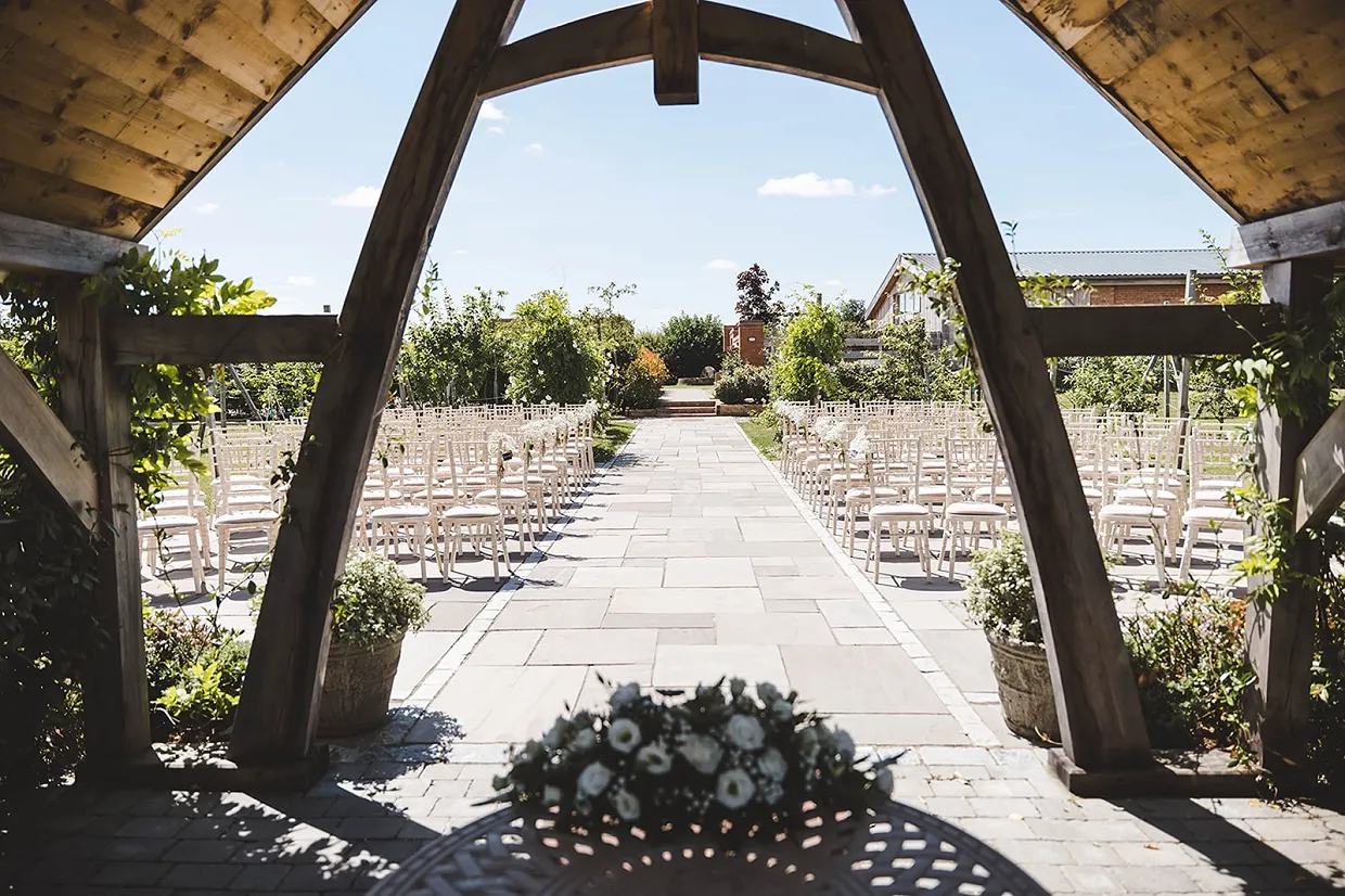Outdoor wedding ceremony at barn wedding venue in the cotswolds with accommodation