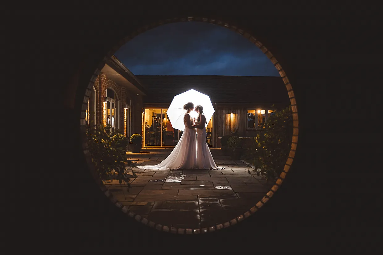 Same Sex wedding couple in twilight at Cotswold Barn wedding venue after outdoor ceremony and reception