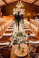 Long tables with brown candelabras and log slices