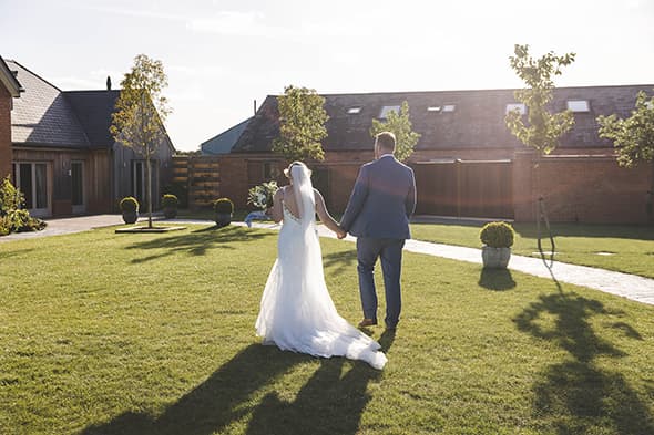 Bride and Groom strolling across the lawn