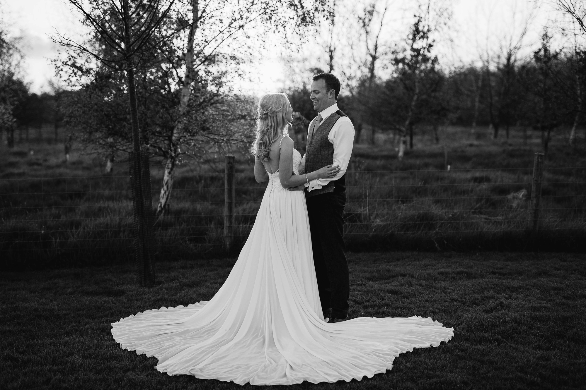 Black and white photo of happy couple in the gardens at sunset